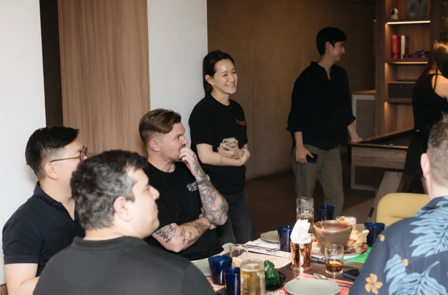 The team laughing together around a table at a team dinner
