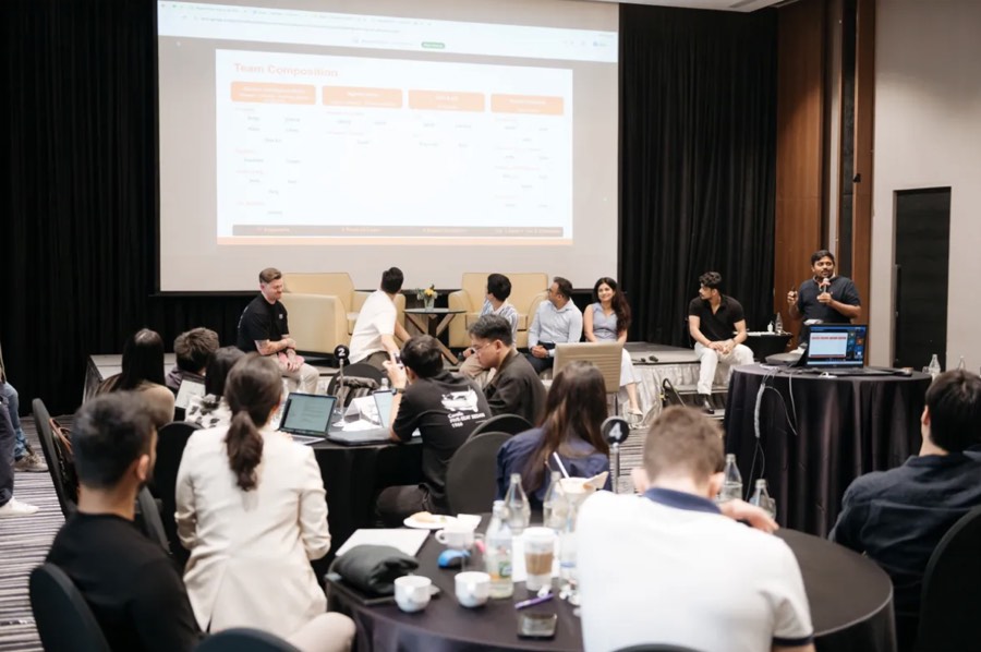 The full team seated together at a company offsite panel discussion